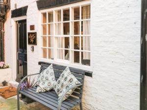 a bench with two pillows sitting in front of a window at Black Gem Cottage in Whitby