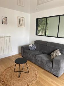 uma sala de estar com um sofá e uma mesa em Zen House 91 em Mennecy