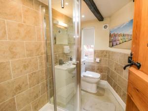 a bathroom with a toilet and a glass shower at Black Gem Cottage in Whitby +21 photos