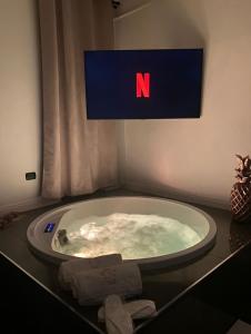 eine Whirlpool-Badewanne mit einem Schild, auf dem n steht in der Unterkunft NM Luxury Suites in Pompei