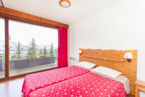 a bedroom with a bed and a large window at Résidences Les Villages du Bachat (by Popinns) in Chamrousse