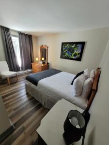 a hotel room with a large bed and a table at Oberge Inn Val-David in Val-David