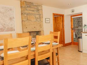 een keuken en eetkamer met een tafel en stoelen bij Curlew Cottage in Keighley