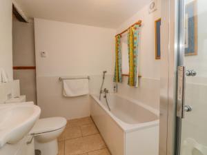 a bathroom with a tub and a toilet and a sink at Curlew Cottage in Keighley +23 photos