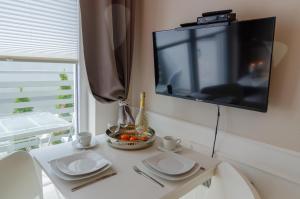 Televízia a/alebo spoločenská miestnosť v ubytovaní Holiday Home SLAVIA NEW S7 z antresolą i balkonem przy plaży + 19 fotografií