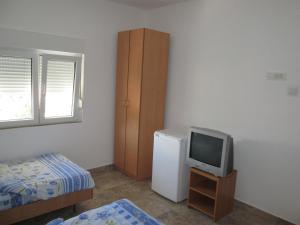 een kleine kamer met een televisie en een koelkast bij Guest House Sandra in Kotor