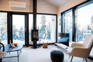 a living room with a fireplace and large windows at Villa Dakota in Syöte