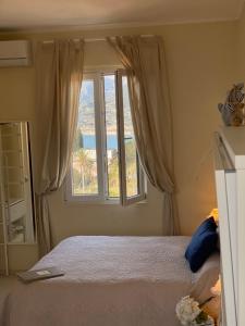 a bedroom with a bed and a large window at Le Storie di Manarola in Manarola