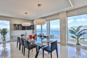 a dining room with a table and chairs and windows at Serenity Penthouse in Lowlands