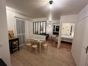 1 dormitorio y sala de estar con mesa y sillas. en Cosy Appart Disney-Paris / RER Val d’Europe à 150m, en Montévrain