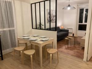 a living room with a table and chairs and a couch at Cosy Appart Disney-Paris / RER Val d’Europe à 150m in Montévrain