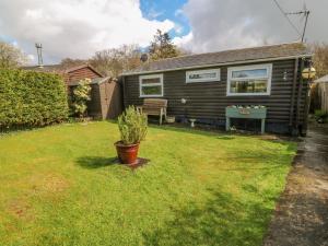 a tiny house in a yard with a bench at Hafan Dawel in Caernarfon