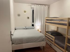 a bedroom with two bunk beds and a window at Cosy Appart Disney-Paris / RER Val d’Europe à 150m in Montévrain