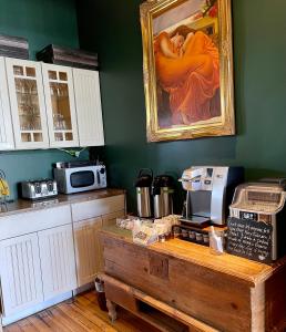 a kitchen with a painting of a woman on the wall at Somerset House Inn in Provincetown