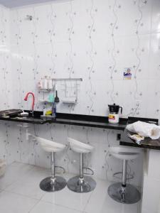 a kitchen with two bar stools in front of a counter at Hostel Aprisco Brasil in Sao Paulo