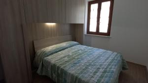 a small bedroom with a bed with a window at Casa Giuditta in Torri del Benaco