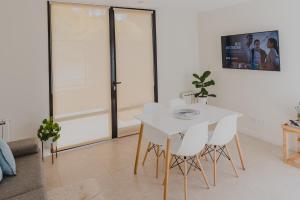 a white dining room with a white table and chairs at El Coiron Aparts in Esquel