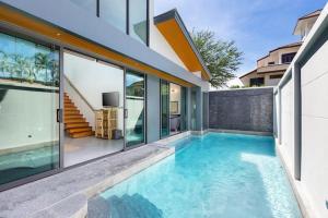 a swimming pool in front of a house at Villa Crystal Two-bedroom private pool villa in Phuket