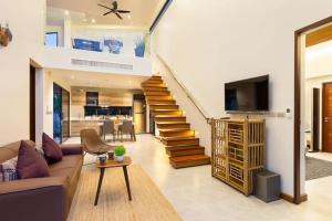 a living room with a couch and a staircase at Villa Crystal Two-bedroom private pool villa in Phuket
