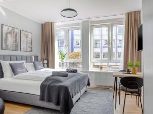 Schlafzimmer mit einem Bett, einem Schreibtisch und Fenstern in der Unterkunft limehome Essen Kettwiger Straße in Essen