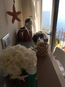 a vase with white flowers on a counter with a window at Le Storie di Manarola in Manarola