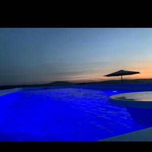 a large blue swimming pool with an umbrella at Masarotto Luxury Chalet #2 in Belgrade