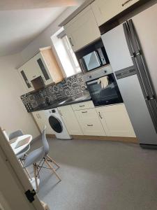 a kitchen with white cabinets and a table and chairs at Memorial Building in Ruthin