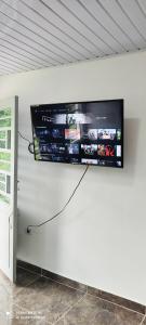 TV de pantalla plana colgada en una pared blanca en Hermoso apartamento con servicios y garaje. en Florencia