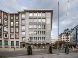 a large brick building on a city street at Limehome Essen Kettwiger Straße in Essen