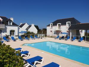 LocmariaにあるLocations LOC'MARIA - Location Professionnelleのスイミングプール(青いラウンジチェア、パラソル付)