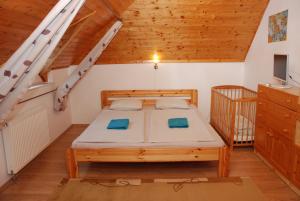 una camera con letto in una stanza con soffitti in legno di Kék Kuckó Vendégház a Fonyód