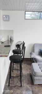 a kitchen with two black chairs and a table at Hermoso apartamento con servicios y garaje. in Florencia