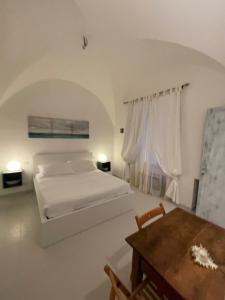 um quarto branco com uma cama e uma mesa em La Casa di Alessia em Camogli