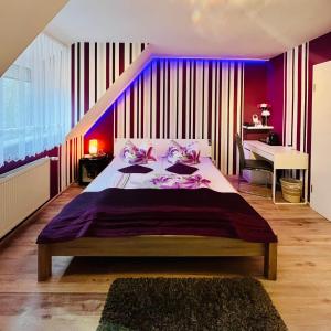 a bedroom with a large bed with purple walls at Georgenberg in Spremberg