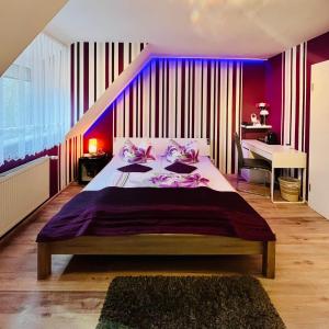 a bedroom with a large bed with purple walls at Georgenberg in Spremberg +41 photos