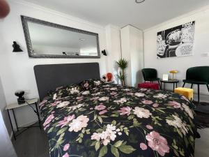 a bedroom with a bed with a floral bedspread at Center City Apartment in Zagreb
