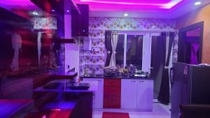 een keuken met paarse verlichting op de muren bij Nath's Residency in Puri