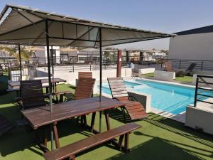 a patio with tables and chairs next to a swimming pool at Punto Urbano in Villa Carlos Paz