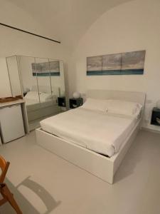 カモーリにあるLa Casa di Alessiaの白いベッドルーム(ベッド1台、鏡付)