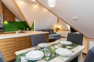 een keuken en een woonkamer met een tafel met borden erop bij Apart4Sleepers Sienkiewicza in Zakopane