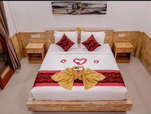 a bedroom with a bed with a heart decoration on it at Pulu Sari Suite Ubud in Ubud