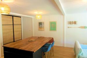 a dining room with a wooden table and blue chairs at Duplex House With Large Terrace And Garden in Moliets-et-Maa