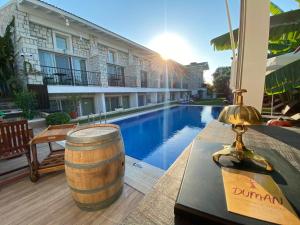 a table with a wine barrel next to a swimming pool at Duman Boutique Hotel Cesme in Çeşme