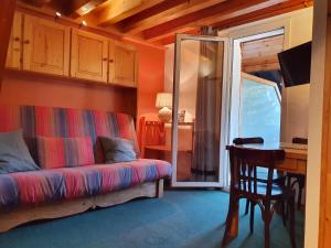 a living room with a couch and a desk at cellier 7 in Les Deux Alpes