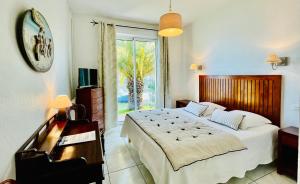 a bedroom with a large bed and a piano at La Caravelle Logis in Biscarrosse