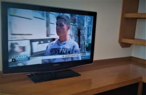 TV de pantalla plana sobre una mesa de madera en Studio 6, en Varsovia