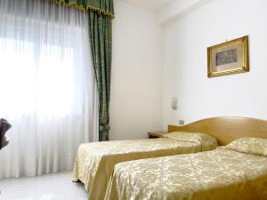 Postel nebo postele na pokoji v ubytování Hotel Reginella