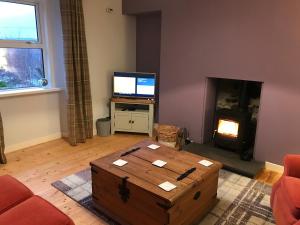 a living room with a coffee table and a tv at Kildinguie - Traditional Cottage - on NC 500 Route in Tongue