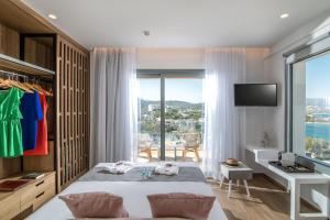 a bedroom with a bed and a desk and a window at Blue Senses Villas in Agios Nikolaos