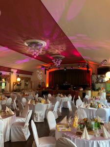 a banquet hall with white tables and white chairs at Georgenberg in Spremberg